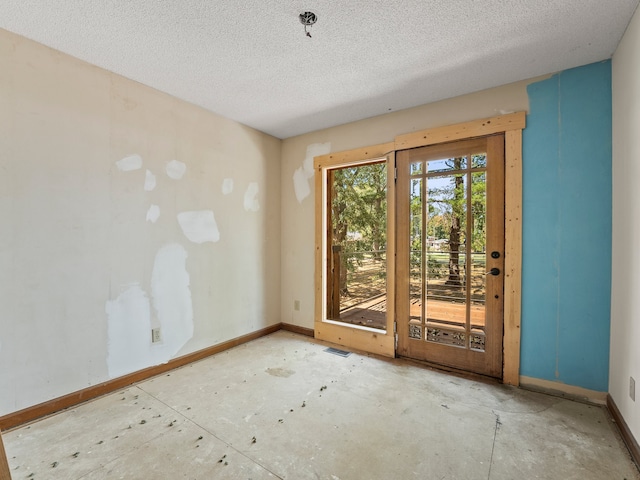 unfurnished room with a textured ceiling