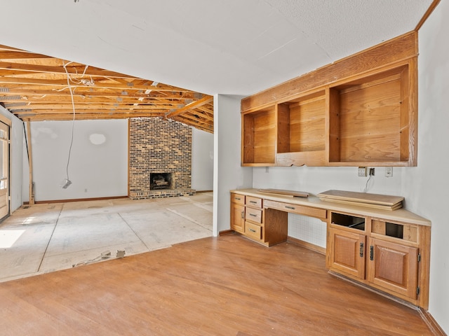 kitchen featuring built in desk, a brick fireplace, and lofted ceiling