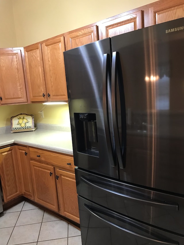 kitchen featuring light tile patterned flooring and stainless steel refrigerator with ice dispenser