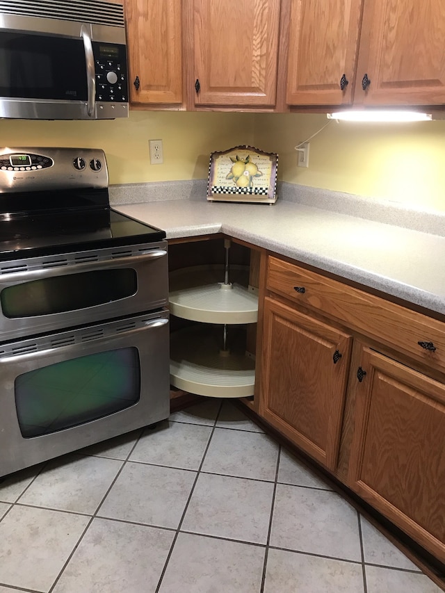 kitchen featuring light tile patterned flooring and appliances with stainless steel finishes