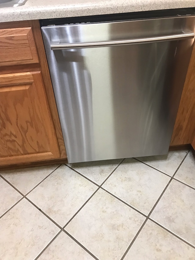 details featuring light tile patterned flooring and dishwasher