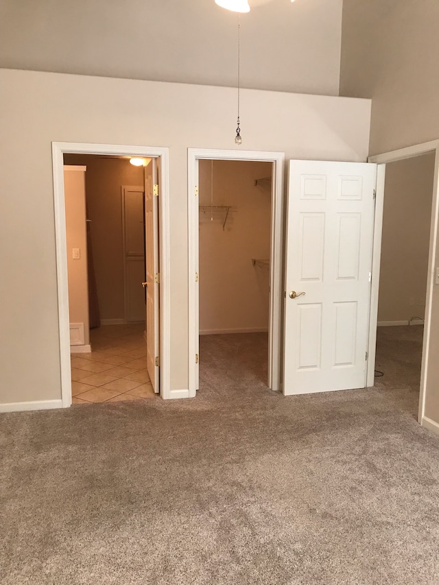 unfurnished bedroom with a closet, carpet flooring, and a walk in closet