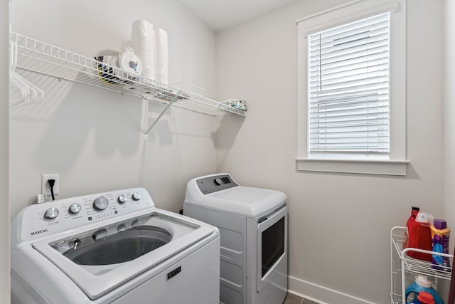 laundry area with washing machine and clothes dryer and a wealth of natural light