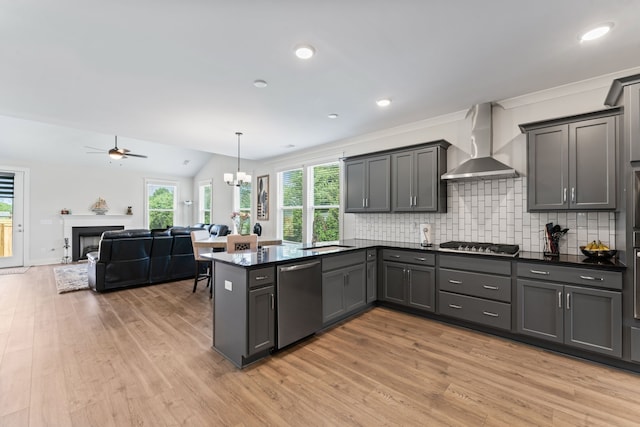 kitchen featuring wall chimney exhaust hood, hanging light fixtures, stainless steel appliances, and gray cabinetry