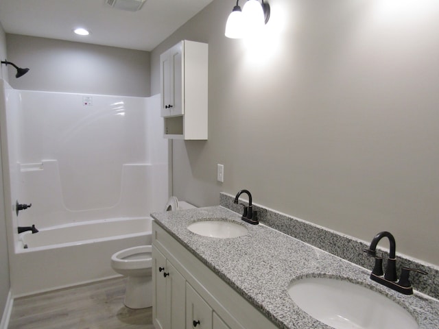 full bathroom with vanity, hardwood / wood-style flooring, toilet, and shower / washtub combination