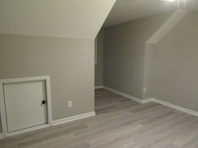 additional living space featuring lofted ceiling, light hardwood / wood-style floors, and ceiling fan