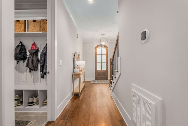 mudroom featuring a notable chandelier, crown molding, and hardwood / wood-style flooring