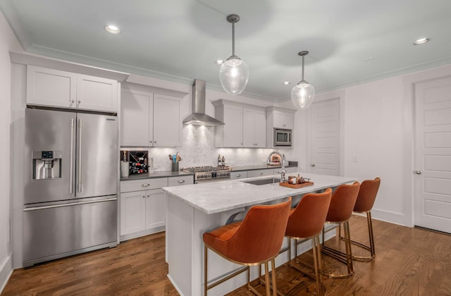 kitchen with dark wood-type flooring, an island with sink, wall chimney exhaust hood, stainless steel appliances, and sink