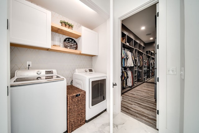 washroom featuring cabinets and washing machine and clothes dryer