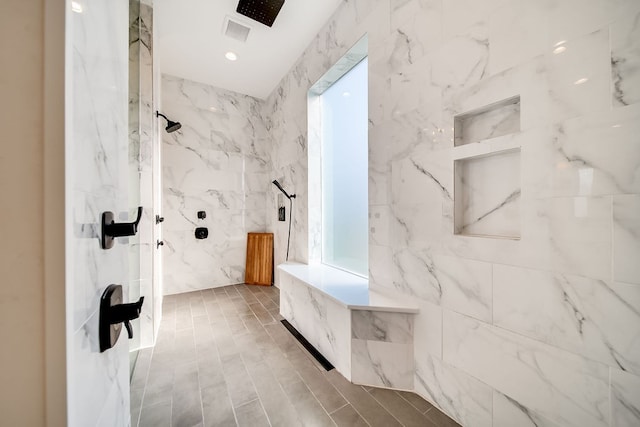 bathroom featuring tile walls and a tile shower