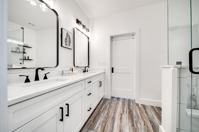 bathroom featuring vanity, hardwood / wood-style flooring, and a shower with door