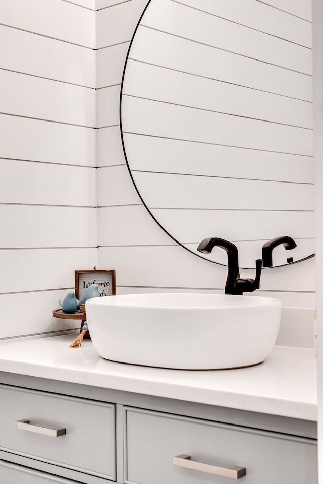 bathroom with vanity and wood walls