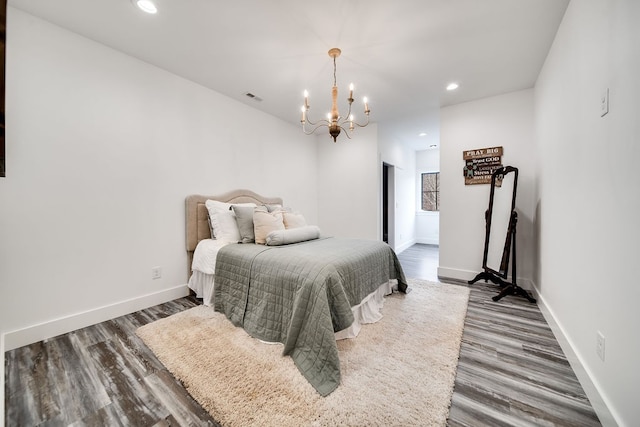 bedroom with an inviting chandelier and dark hardwood / wood-style flooring