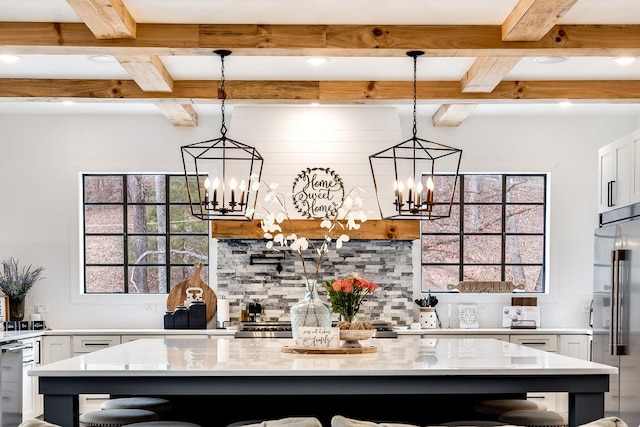 kitchen featuring high quality fridge, a breakfast bar, a center island, and light stone counters