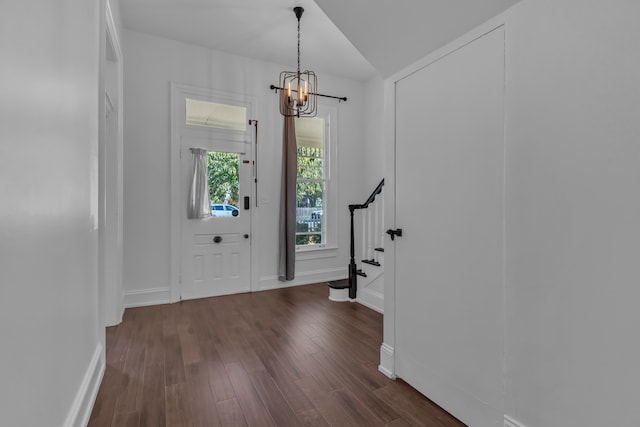 entrance foyer featuring lofted ceiling, dark hardwood / wood-style floors, and a notable chandelier