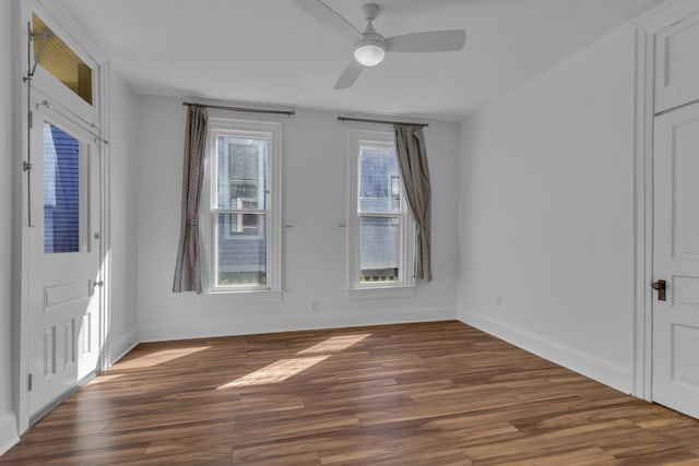 empty room with dark hardwood / wood-style floors and ceiling fan