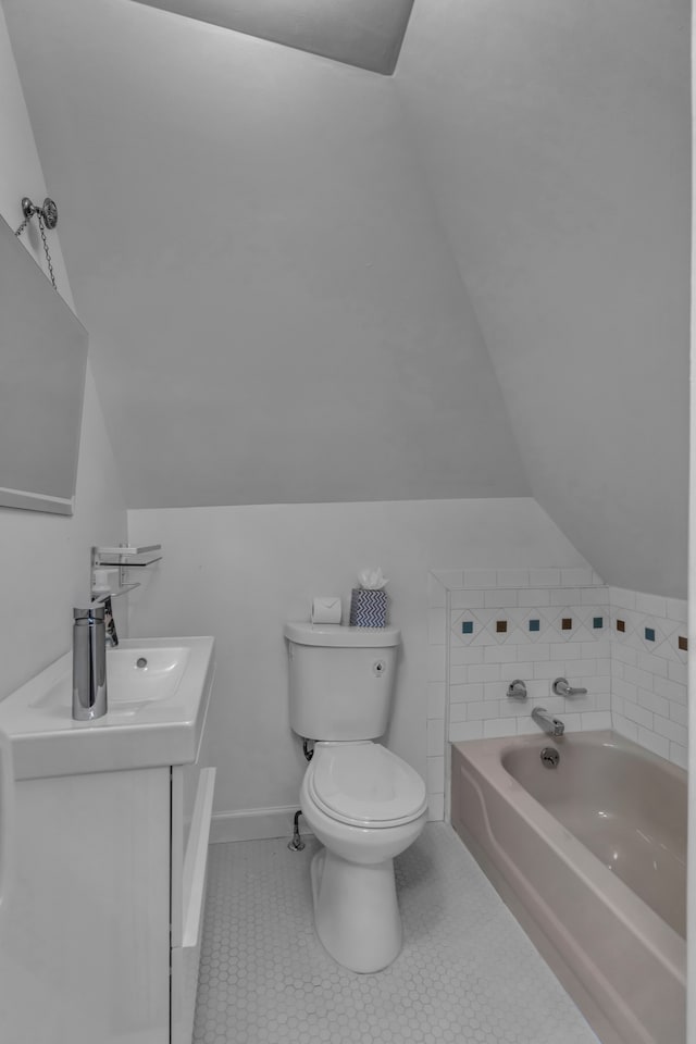 bathroom featuring a tub, tile patterned flooring, vaulted ceiling, toilet, and vanity