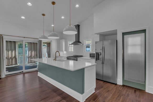 kitchen featuring stainless steel appliances, a healthy amount of sunlight, sink, pendant lighting, and white cabinetry