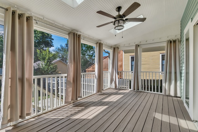 unfurnished sunroom featuring ceiling fan and a skylight