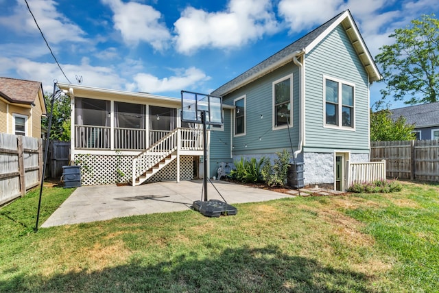 back of house with a sunroom, a patio area, and a yard