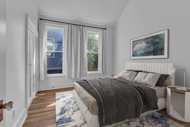 bedroom with dark hardwood / wood-style flooring and vaulted ceiling