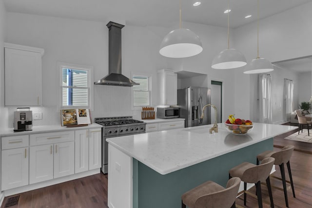 kitchen with a center island with sink, decorative light fixtures, and appliances with stainless steel finishes