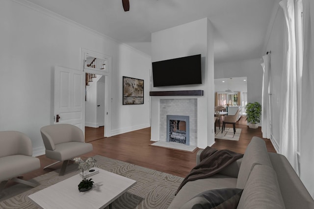 living room featuring hardwood / wood-style floors, ceiling fan, and ornamental molding