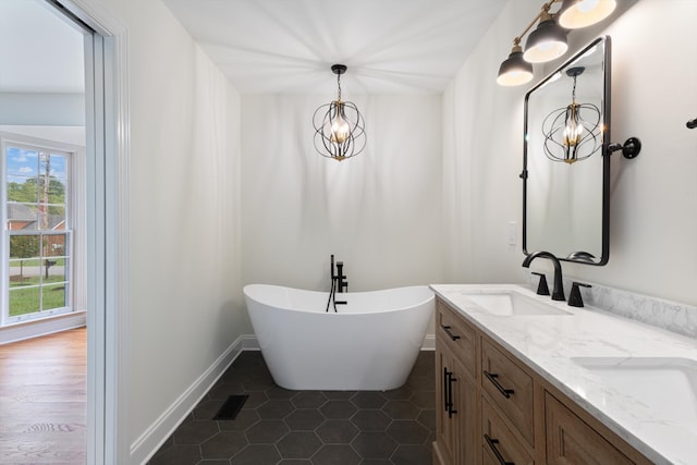 bathroom featuring vanity, a chandelier, hardwood / wood-style flooring, and a tub