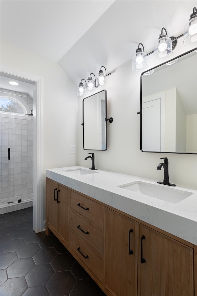 bathroom featuring a tile shower, tile patterned flooring, vanity, and lofted ceiling