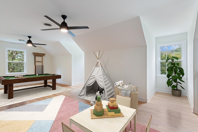 recreation room with ceiling fan, light wood-type flooring, lofted ceiling, and a healthy amount of sunlight