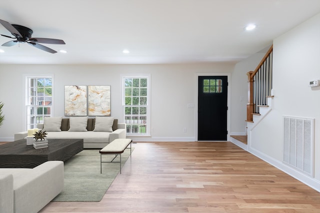 living room featuring ceiling fan, light hardwood / wood-style flooring, and a wealth of natural light