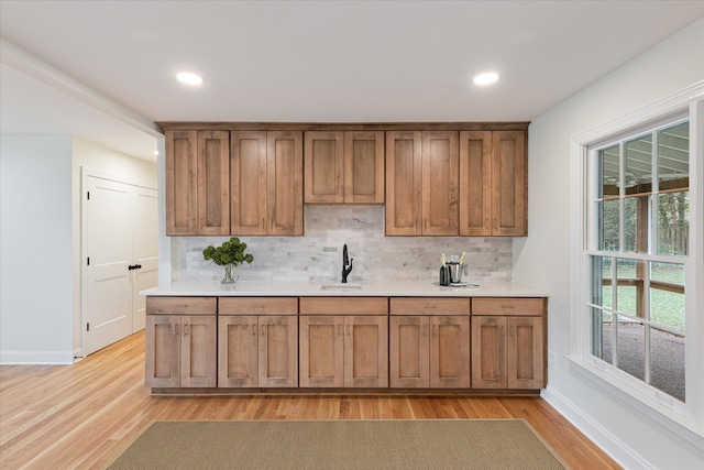 kitchen featuring light hardwood / wood-style floors, sink, and tasteful backsplash