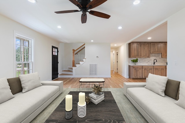 living room with ceiling fan and light hardwood / wood-style floors