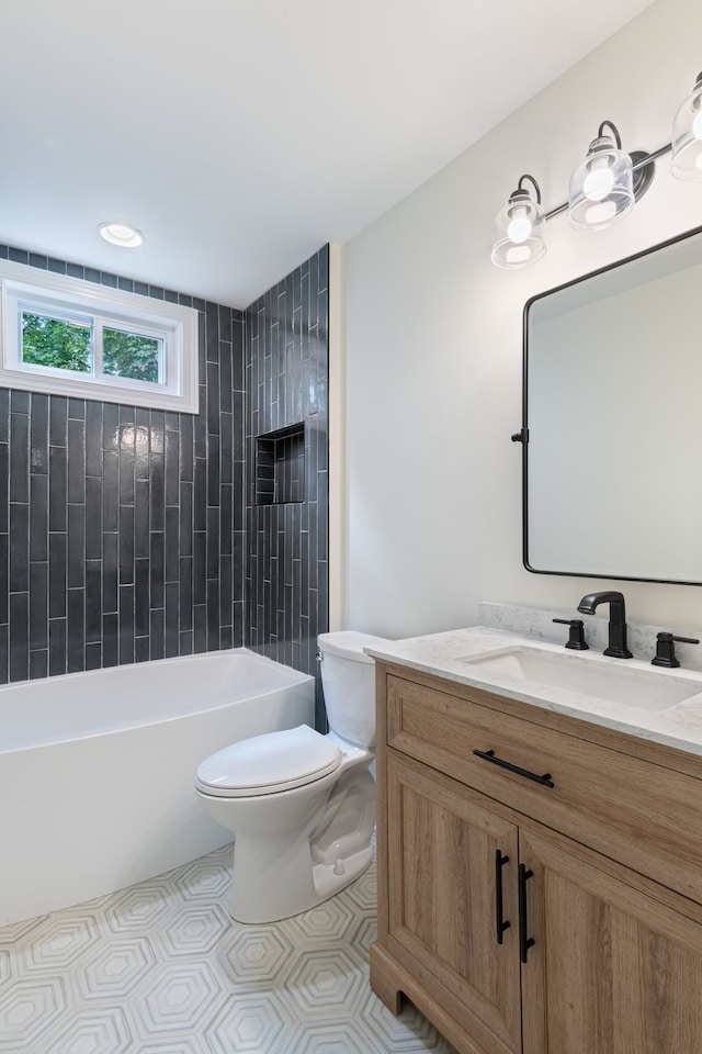 full bathroom with tile patterned flooring, tiled shower / bath, vanity, and toilet