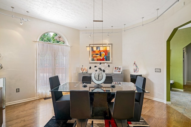 dining space featuring a textured ceiling and light hardwood / wood-style flooring