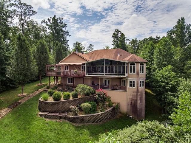 back of property featuring a sunroom and a yard