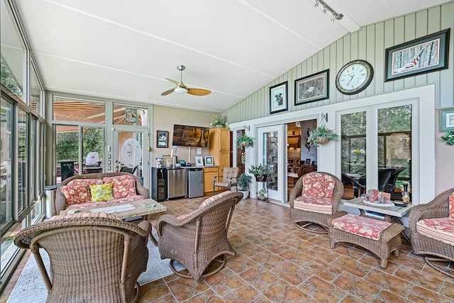 sunroom featuring a wealth of natural light, vaulted ceiling, ceiling fan, and rail lighting