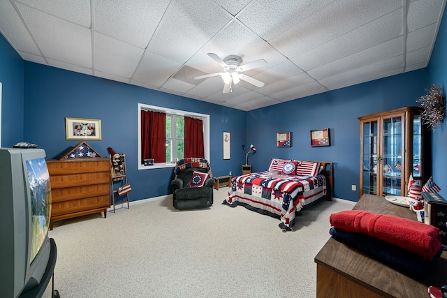 carpeted bedroom with ceiling fan and a drop ceiling