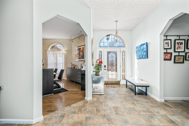 foyer entrance featuring an inviting chandelier and a textured ceiling