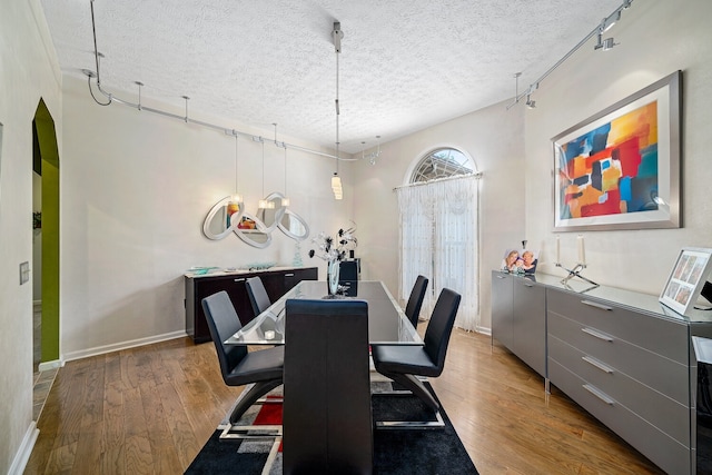 dining room with a textured ceiling and hardwood / wood-style floors