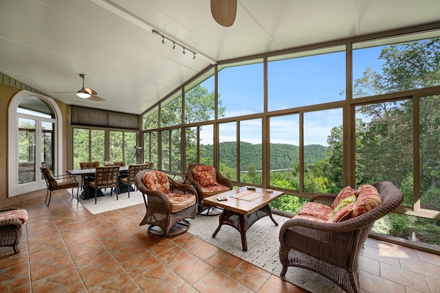 sunroom / solarium featuring vaulted ceiling, track lighting, ceiling fan, and a wealth of natural light