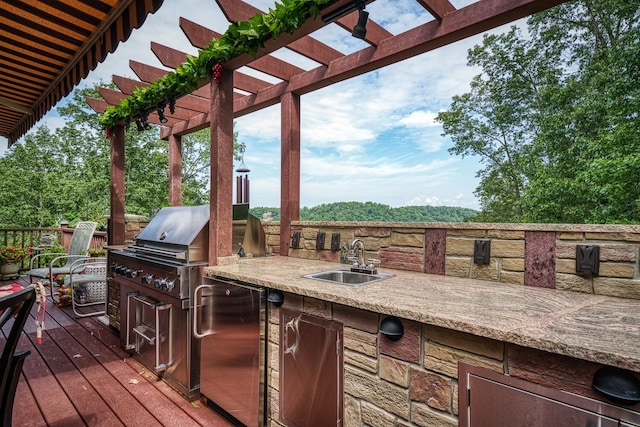 wooden deck featuring area for grilling, a pergola, and sink