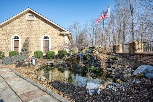 view of property exterior featuring a small pond