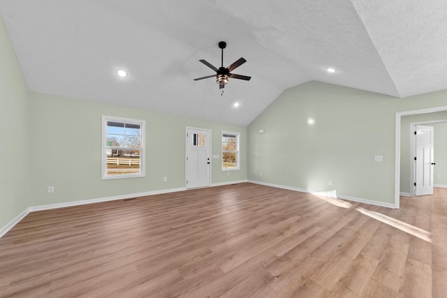 unfurnished living room with vaulted ceiling, light wood-style flooring, and baseboards