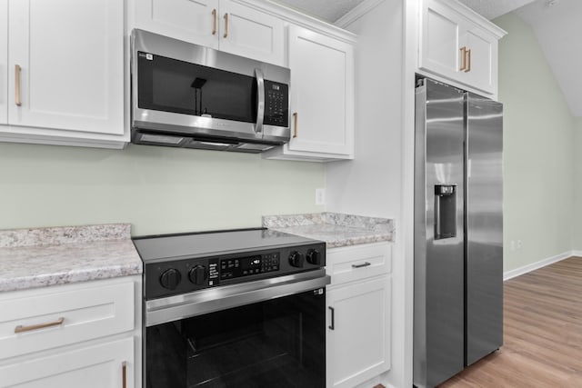 kitchen with baseboards, white cabinets, light stone counters, stainless steel appliances, and light wood-type flooring