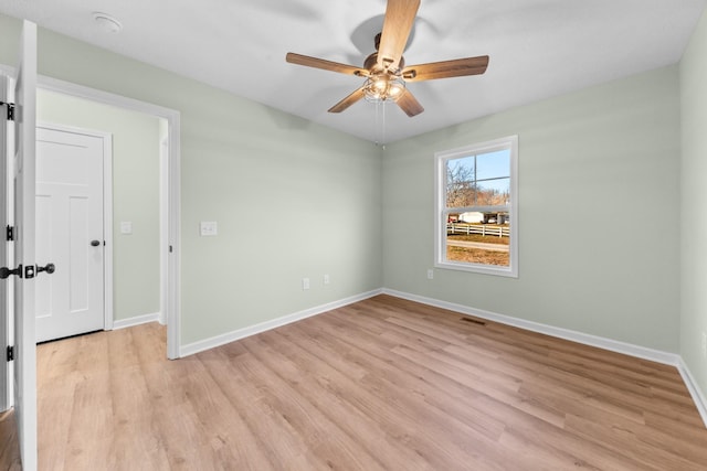 unfurnished room with light wood-style floors, visible vents, ceiling fan, and baseboards