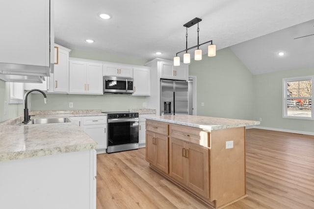 kitchen with light wood finished floors, appliances with stainless steel finishes, light countertops, and a sink