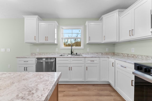 kitchen with white cabinets, a sink, stainless steel dishwasher, and stove