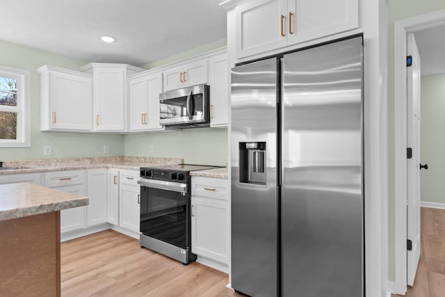 kitchen featuring light wood-style flooring, appliances with stainless steel finishes, light stone countertops, white cabinetry, and recessed lighting