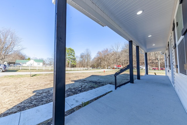 view of patio featuring a porch and fence